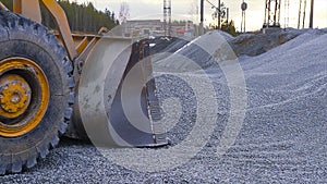 Tractor moves rubble to truck. Stock footage. Excavator-loader rakes rubble from pile at construction site and loads