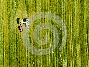 Tractor mowing agricultural field. Aerial view. Cultivating field.