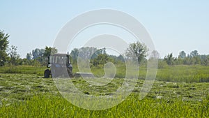 Tractor mowing grass in meadow