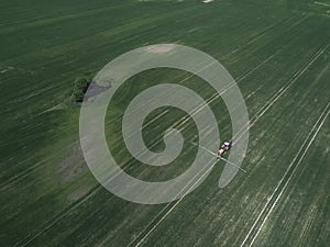 Tractor mowing green field, aerial view