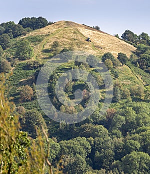 Tractor mowing a track,through grass on steep slope of Malvern Hills,England,U.K