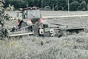 Tractor mows the grass. harvesting hay for the winter