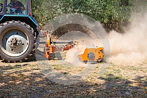 tractor with a mulcher crushes and levels the top layer of soil. Agricultural work