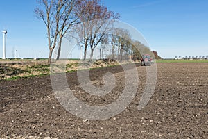 Tractor plough at bare Dutch field in early springtime