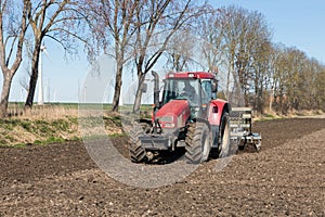 Tractor plough at bare Dutch field in early springtime