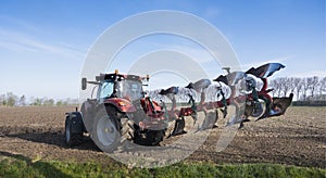 tractor with plough on field early spring in the netherlands on the island of goeree en overflakkee