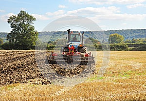 Tractor Ploughing over a field of Wheat stubble