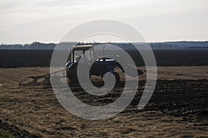 The tractor ploughs up the earth in the spring