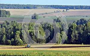 A tractor with a plow plows a rural field. Agricultural work in the economy of the village of Bogorodsk Oktyabrsky district of Pe