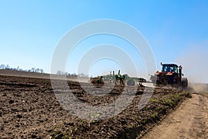 Tractor with Plow Tilling a Field