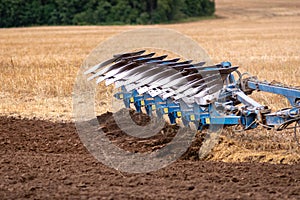 A tractor with a plow treats the soil.