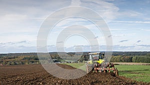 Tractor and plow under blue sky on field in luxembourgh