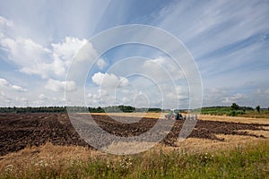 Tractor plowing farmland after harvest