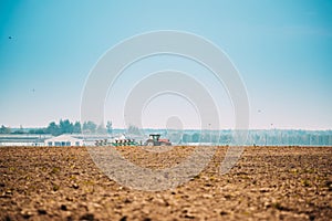 Tractor Plowing Field In Autumn Season