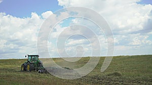 Tractor plowing field with the grass in 4K