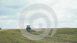 Tractor plowing field with the grass in 4K