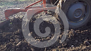 Tractor plowing the field, preparing the land for planting, closeup