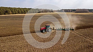 Tractor plowing field side view