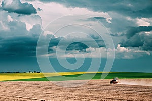 Tractor Plowing Field In Spring Season. Beginning Of Agricultura