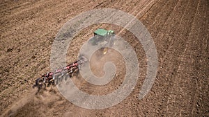 tractor plowing field top view, aerial photography with drone.