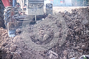 Tractor plowing soil pile for adjust before house building