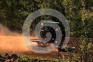 Tractor plowing at sunset time