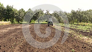 The tractor plows the field, cultivates the soil for sowing grain.