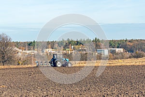 The tractor plows a field, cultivates the soil for sowing grain