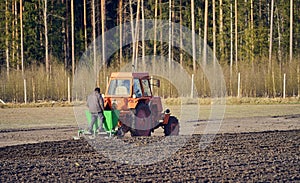 The tractor plows the field, cultivates the soil for sowing grain.