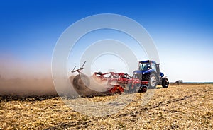 The tractor plows the field, cultivates the soil for sowing grain. The concept of agriculture