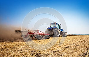 The tractor plows the field, cultivates the soil for sowing grain. The concept of agriculture