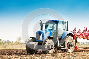 The tractor plows the field, cultivates the soil for sowing grain. The concept of agriculture