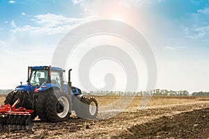 The tractor plows the field, cultivates the soil for sowing grain. The concept of agriculture