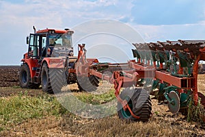 Tractor plows field, cultivators soil for sowing