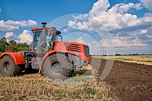 Tractor plows field, cultivators soil for sowing