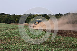 Tractor plows the field in the spring.