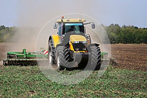 Tractor plows the field in the spring.