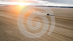 Tractor plows the field at sunset. Agriculture view aerial photography