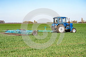 Tractor plows a green field in the spring photo