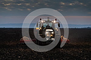 Tractor preparing land with seedbed cultivator