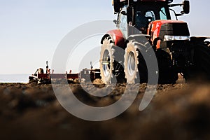 Tractor preparing land with seedbed cultivator