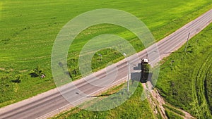 Tractor pulling a full cart with mowed green grass, aerial view.