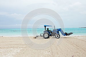 Tractor pulling rake to smooth the beach