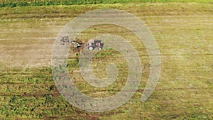 Tractor raking green grass using a rake-tedder