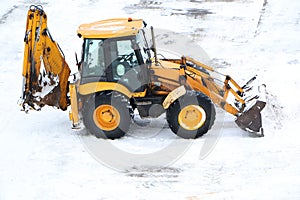 The tractor removes snow in winter. A tractor cleans the road for cars in winter. Equipment cleans the road for pedestrians in