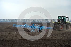 Tractor with seedbed cultivator preparing land in spring time