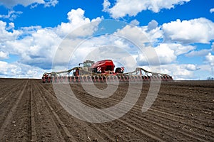 Tractor with seeder in the field in early spring