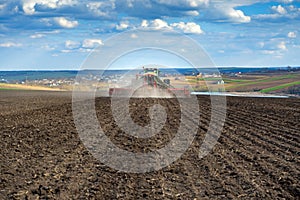 Tractor with seeder in the field in early spring