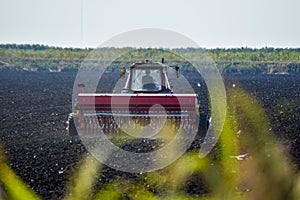 Tractor with a seeder in the field. sowing seeds in the soil.