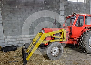 Tractor in a shed with haystacks